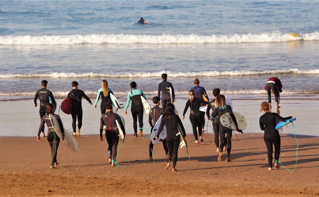 Group of surfers walk towards the water